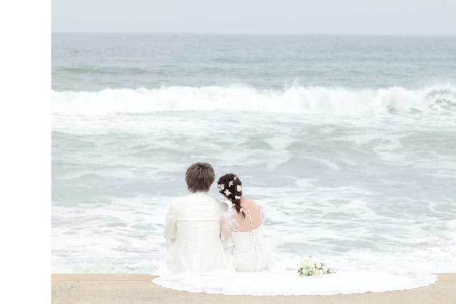 海を背景に洋装の新郎新婦の後姿